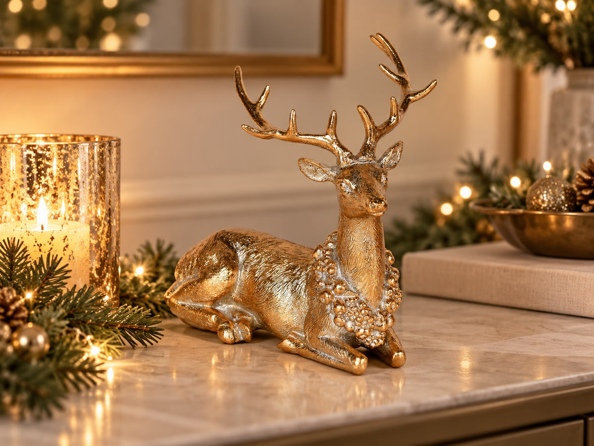 Gold resting reindeer styled with gilded fir trees and Christmas greenery