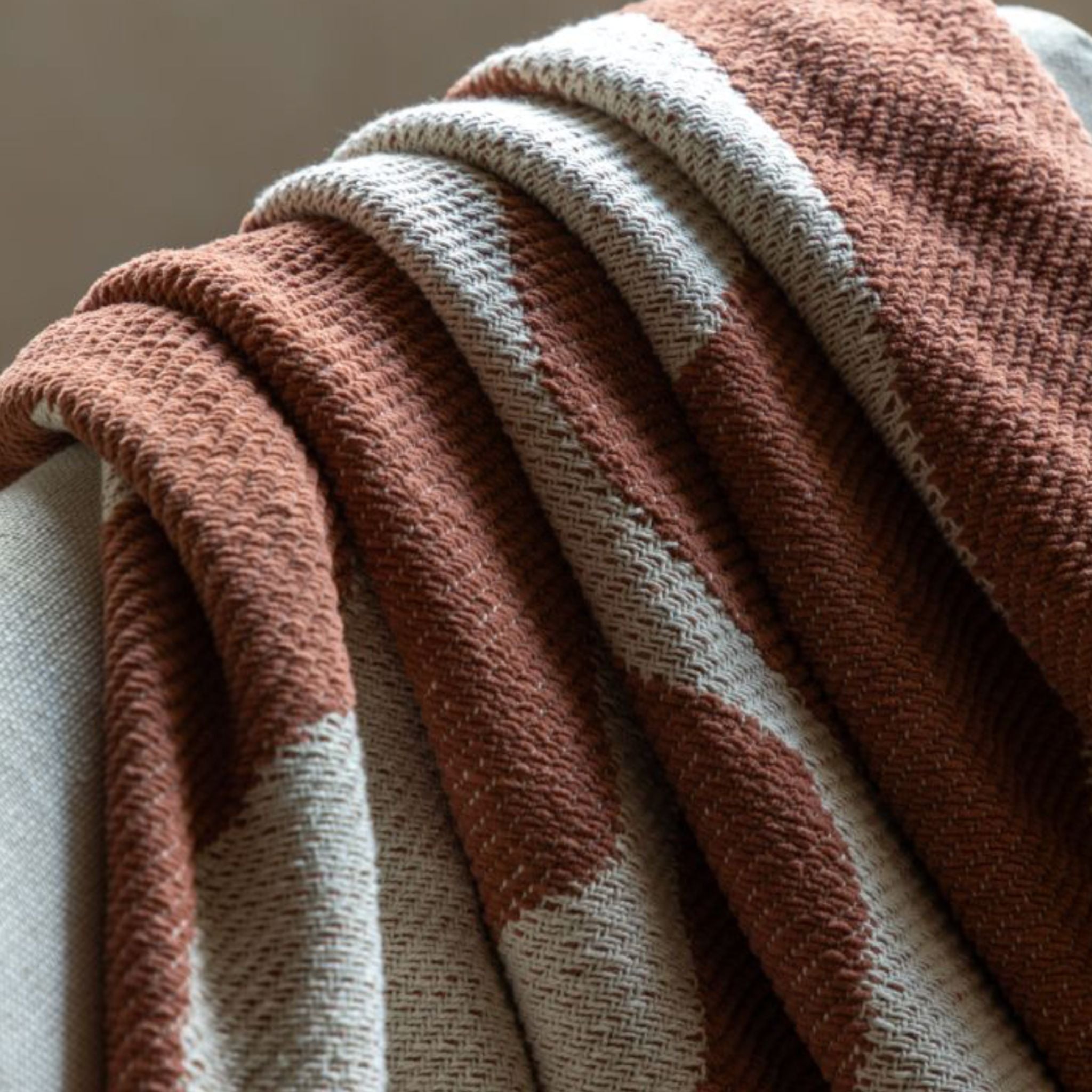 Textured brown and cream blanket on a neutral background