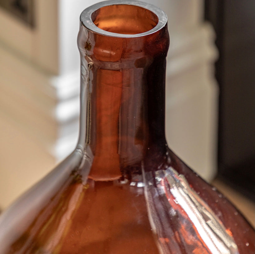 Close-up of an amber glass bottle with a blurred background