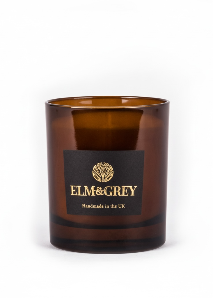 Amber glass candle with Elm & Grey label on a white background