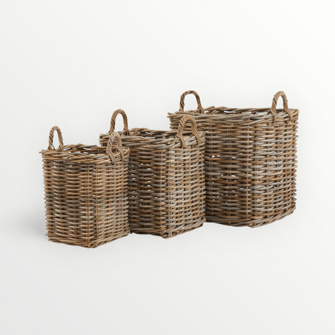 Three square rattan storage baskets in different sizes with natural rattan texture and two woven handles on each basket.