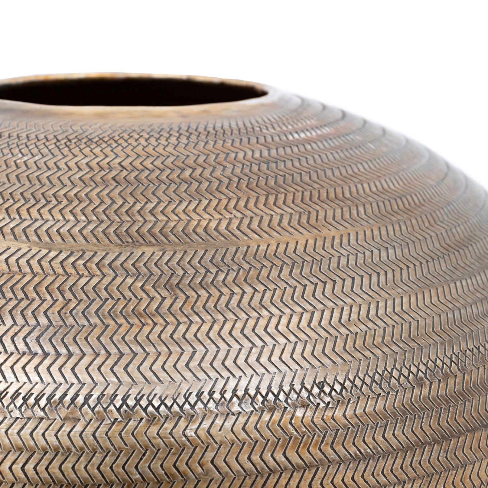 Close-up of a textured antiqued brass vase on a white background