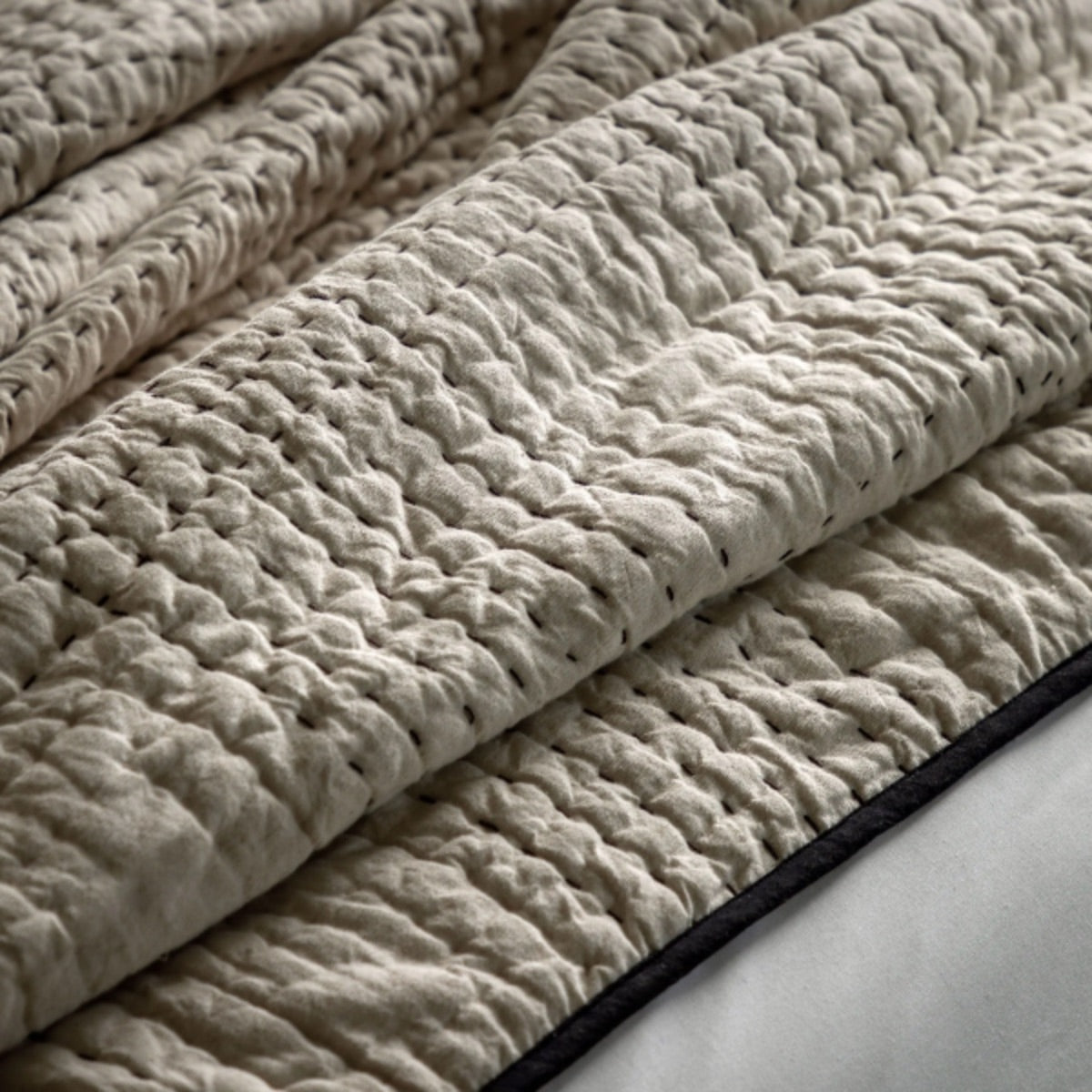 Stack of textured beige fabric on a white surface