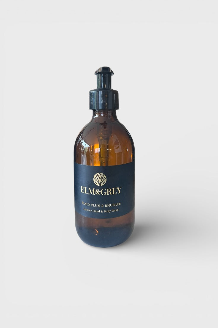 Amber glass bottle with pump dispenser labeled 'Elm & Grey' on a white background