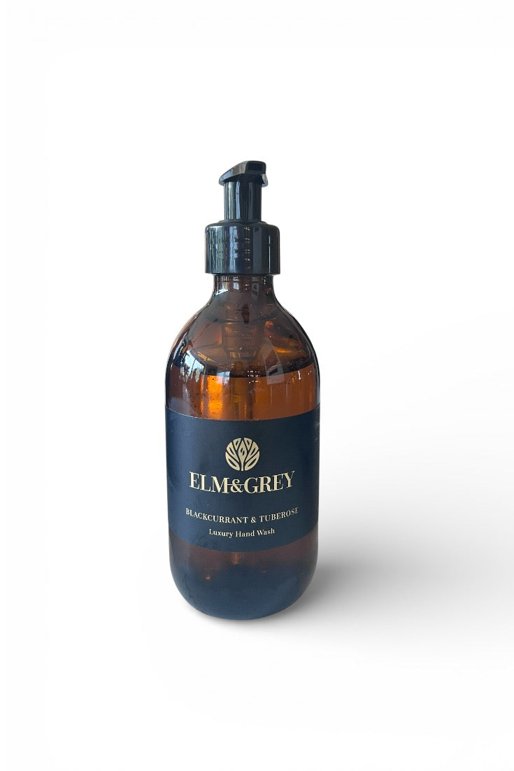 Amber brown bottle with pump dispenser labeled 'Elm & Grey' on a white background