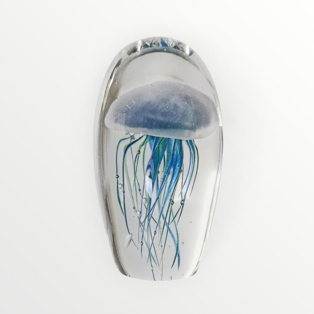 Glass sculpture of a jellyfish with blue tentacles on a white background, Elm & Grey.