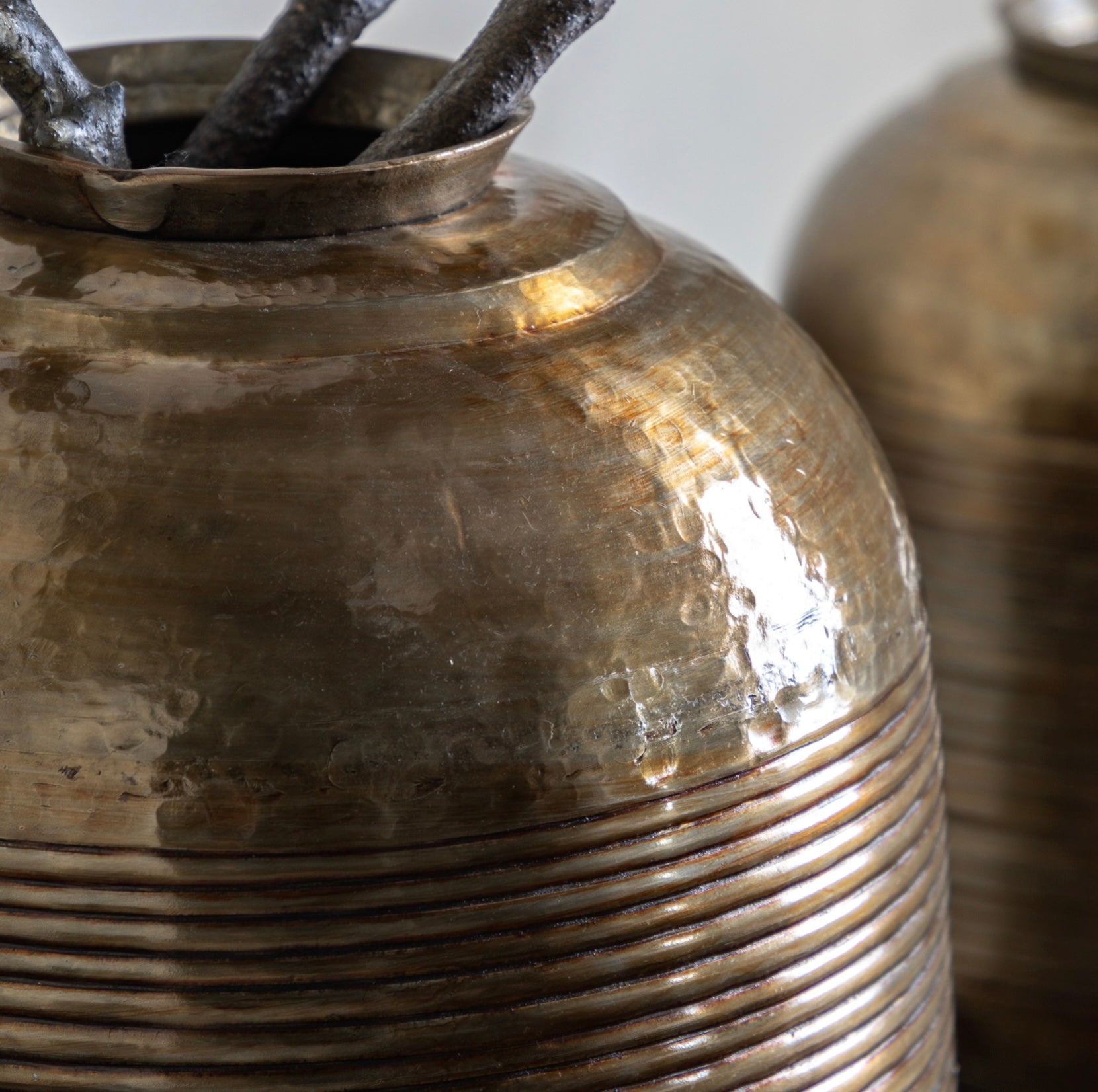 Decorative metallic vase with ribbed design and dark interior