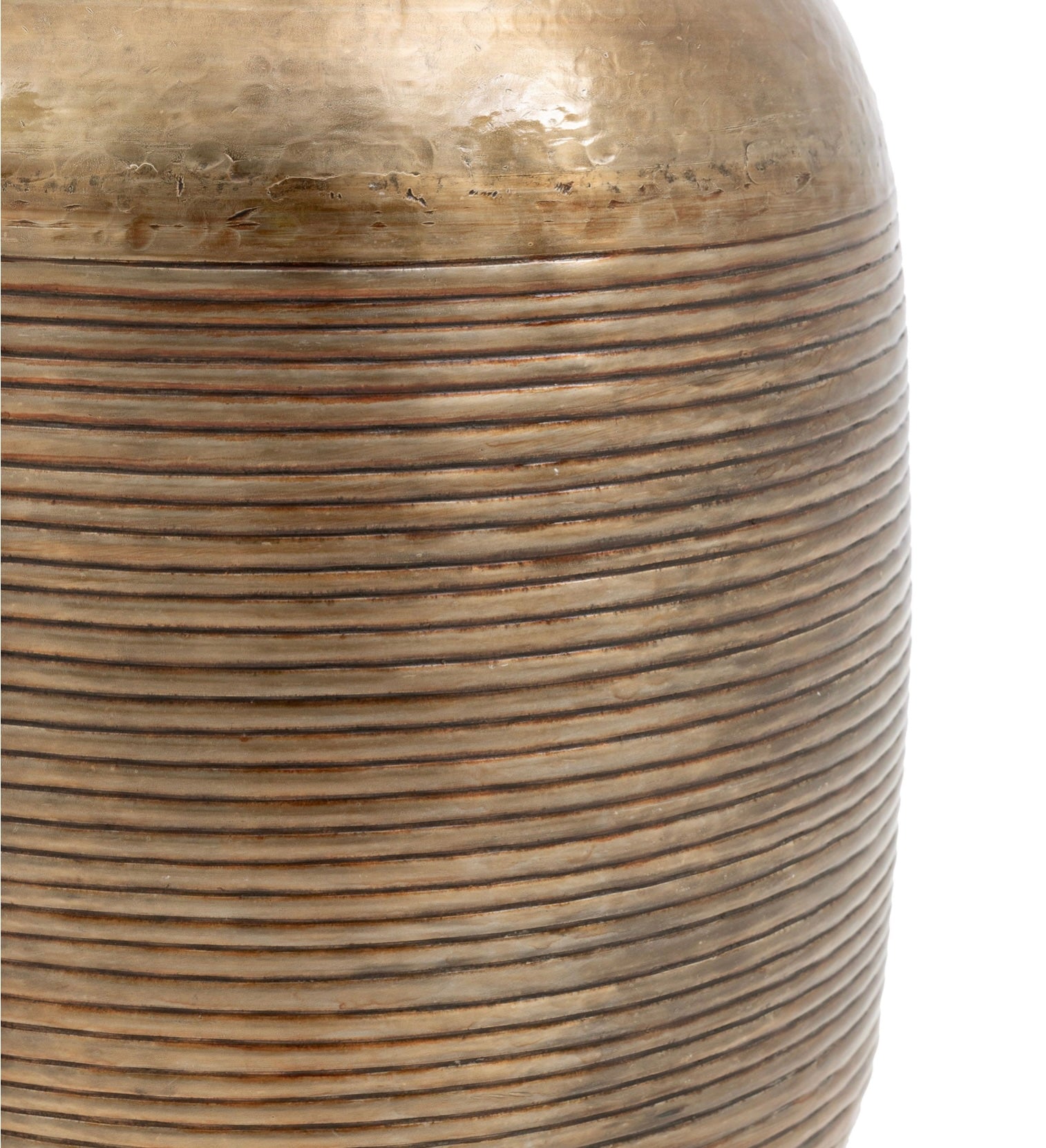 Close-up of a textured bronze metallic vase with concentric circular patterns.