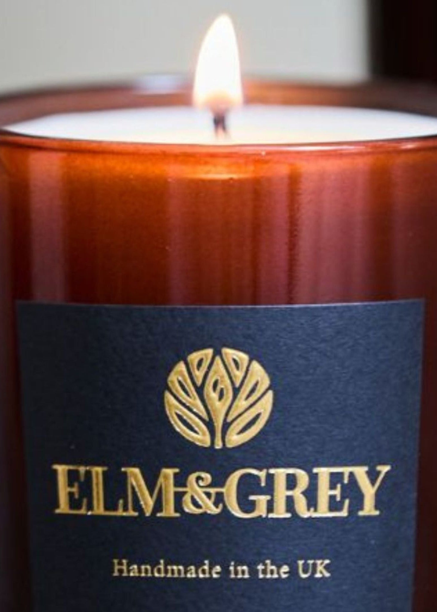 Candle with 'Elm & Grey' label on a dark background