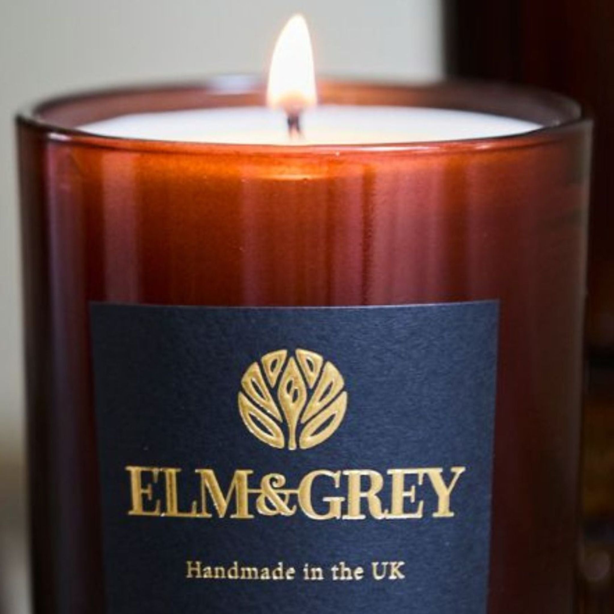 Candle with 'Elm & Grey' label on a dark background