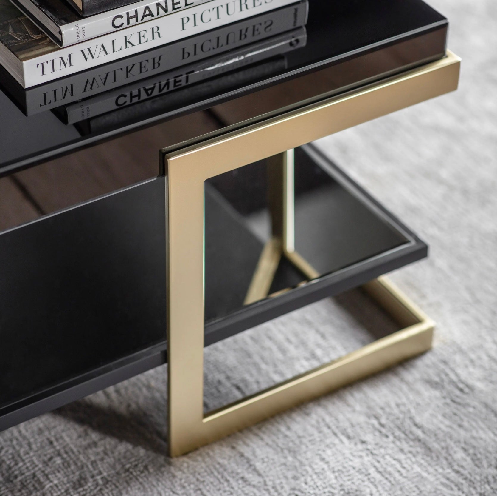 Black and gold coffee table with books on a grey surface