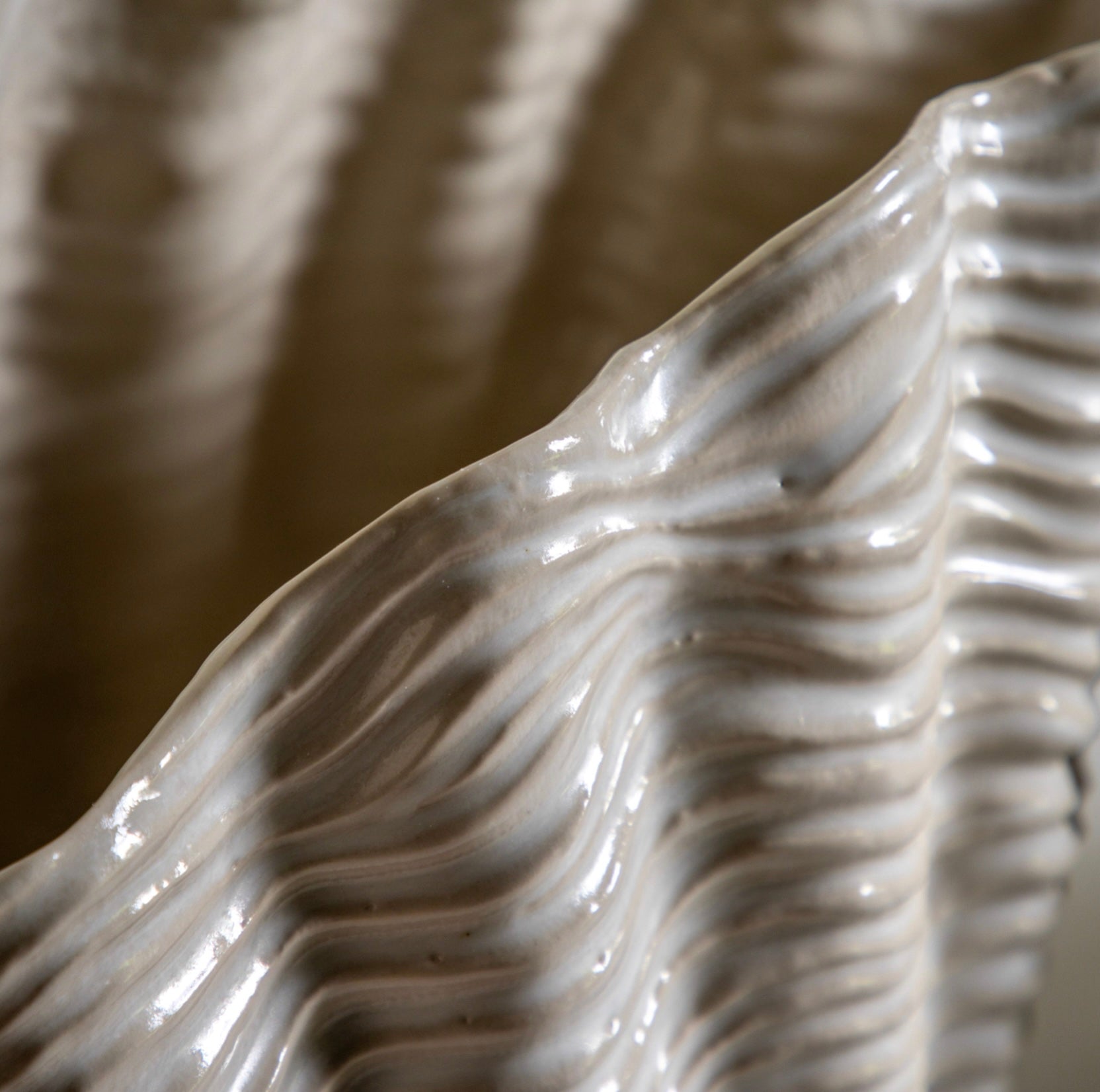 Close-up of a textured ceramic clam vase with wavy design