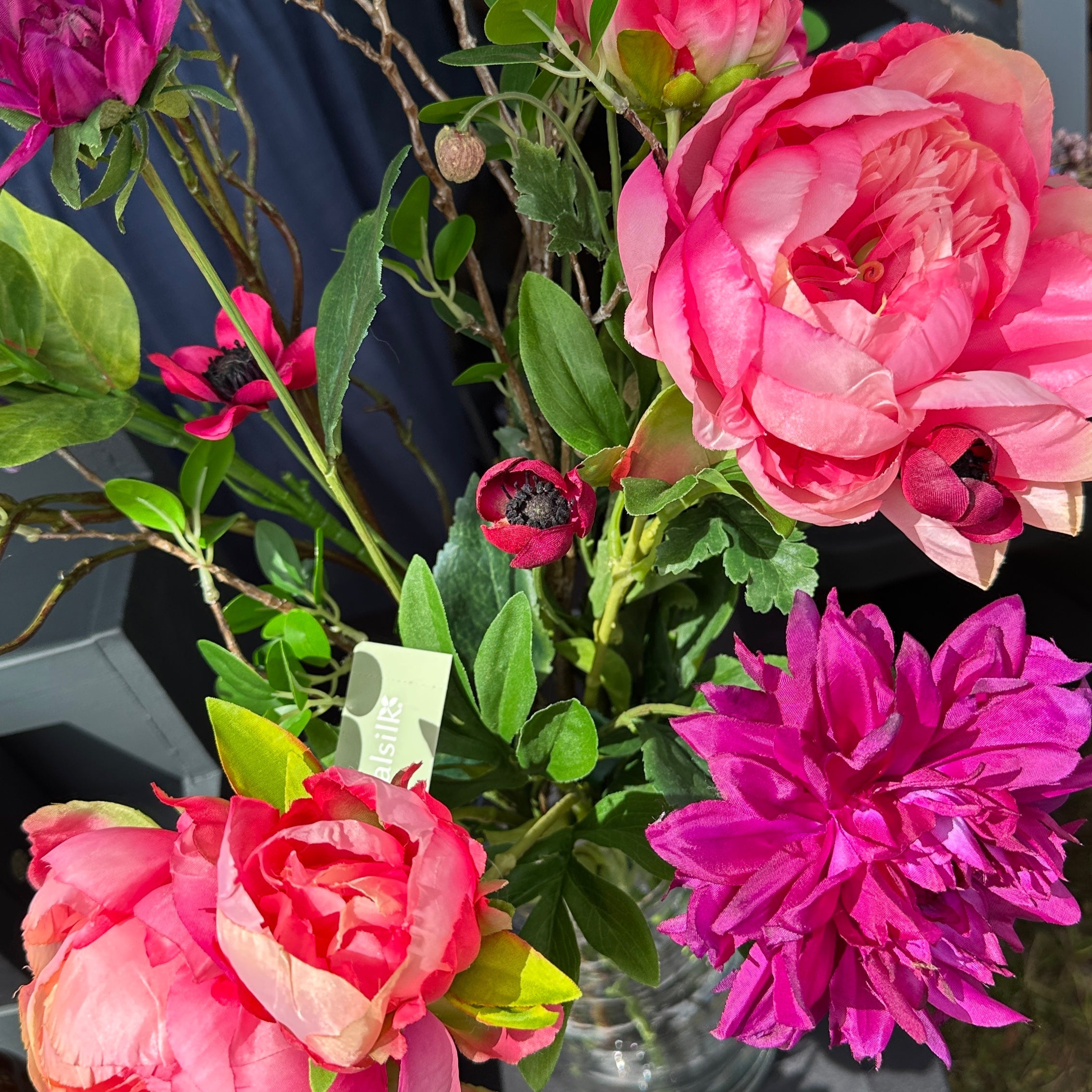 Bouquet of pink and purple flowers in a clear vase on a table.