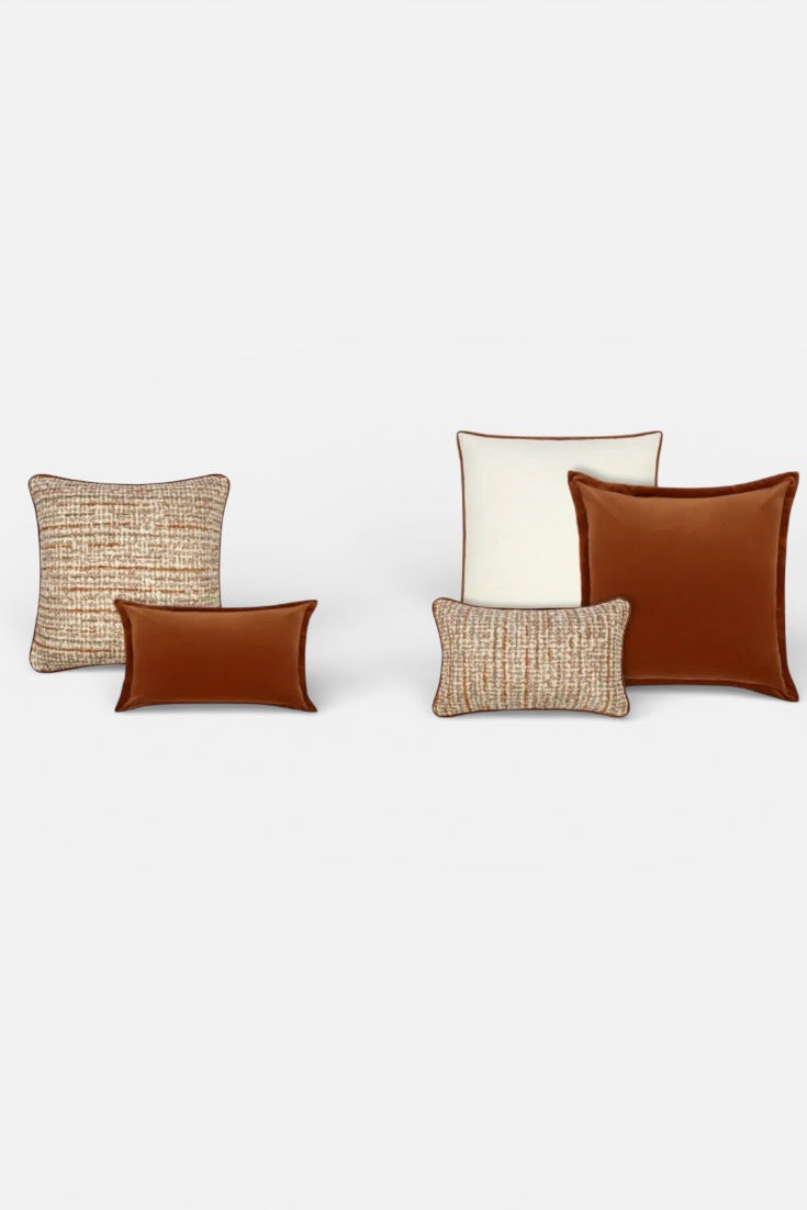 Five cushions of different colours and textures on a white background