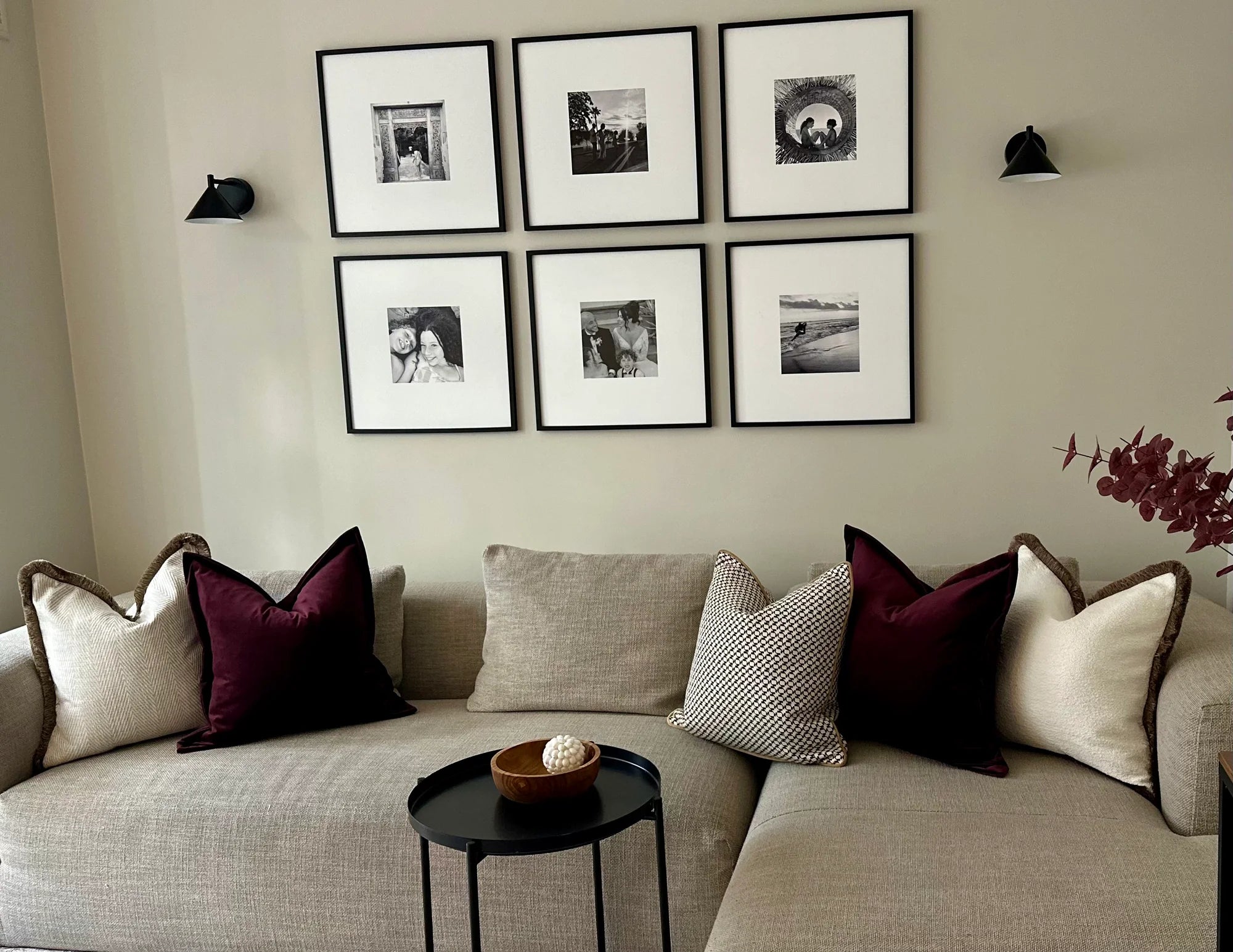 Living room with a beige sofa, decorative pillows, and framed pictures on the wall.