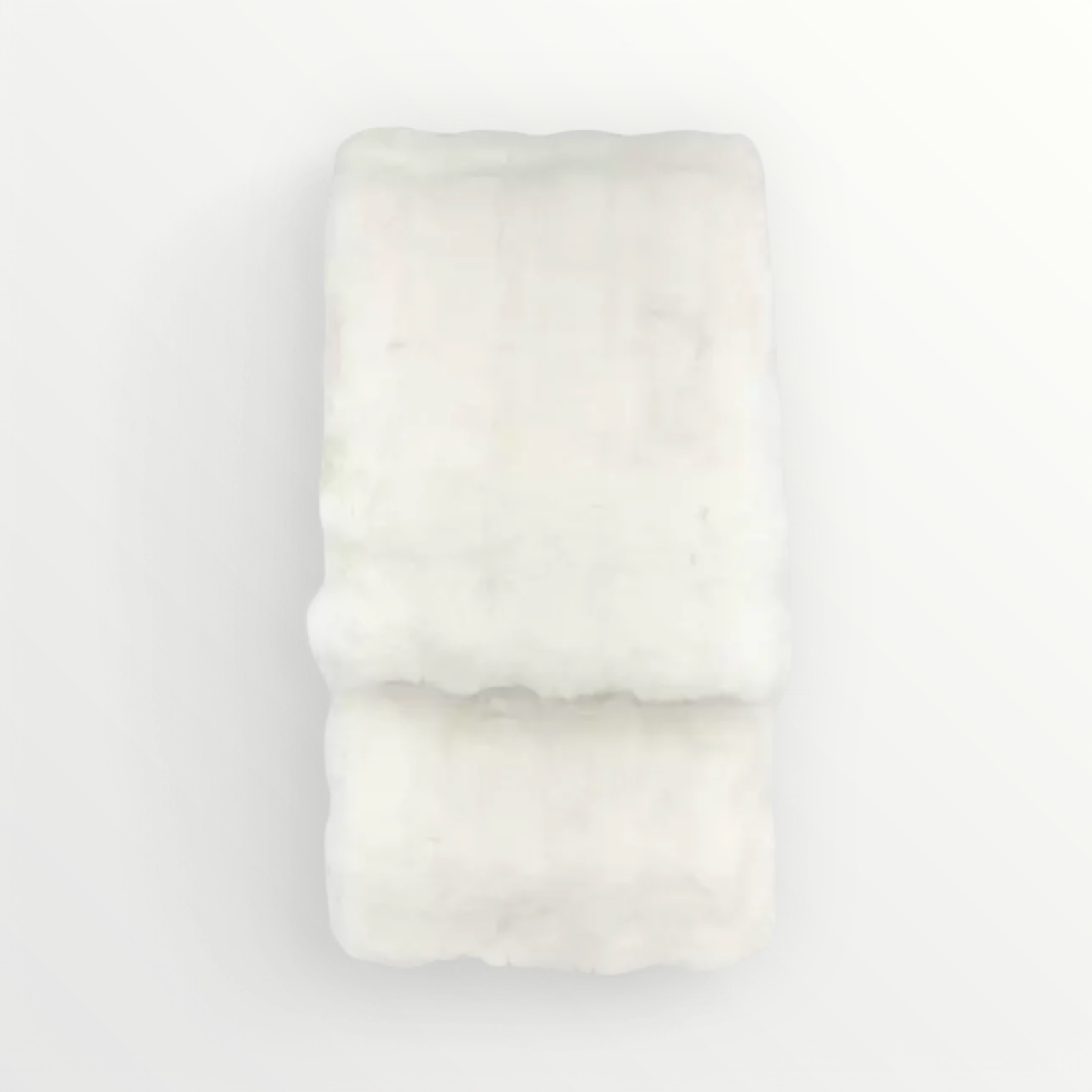 A creamy white faux fur cushion with a plush texture, displayed against a white background.