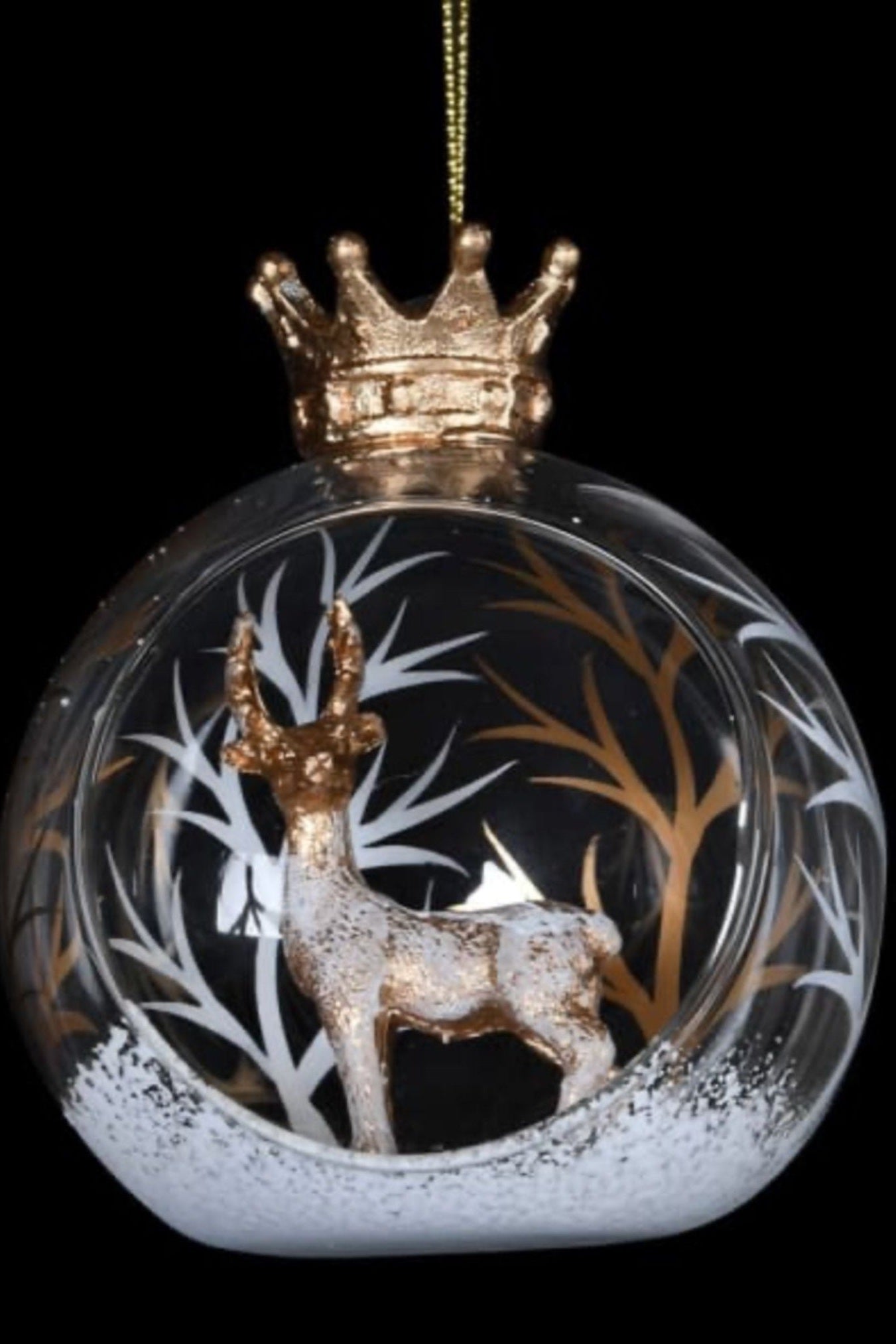 Decorative glass ball with a deer and crown design on a black background