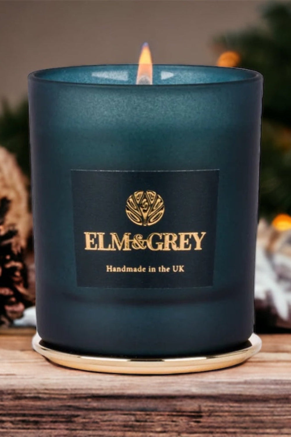 Blue candle with 'ELM & GREY' branding on a wooden surface