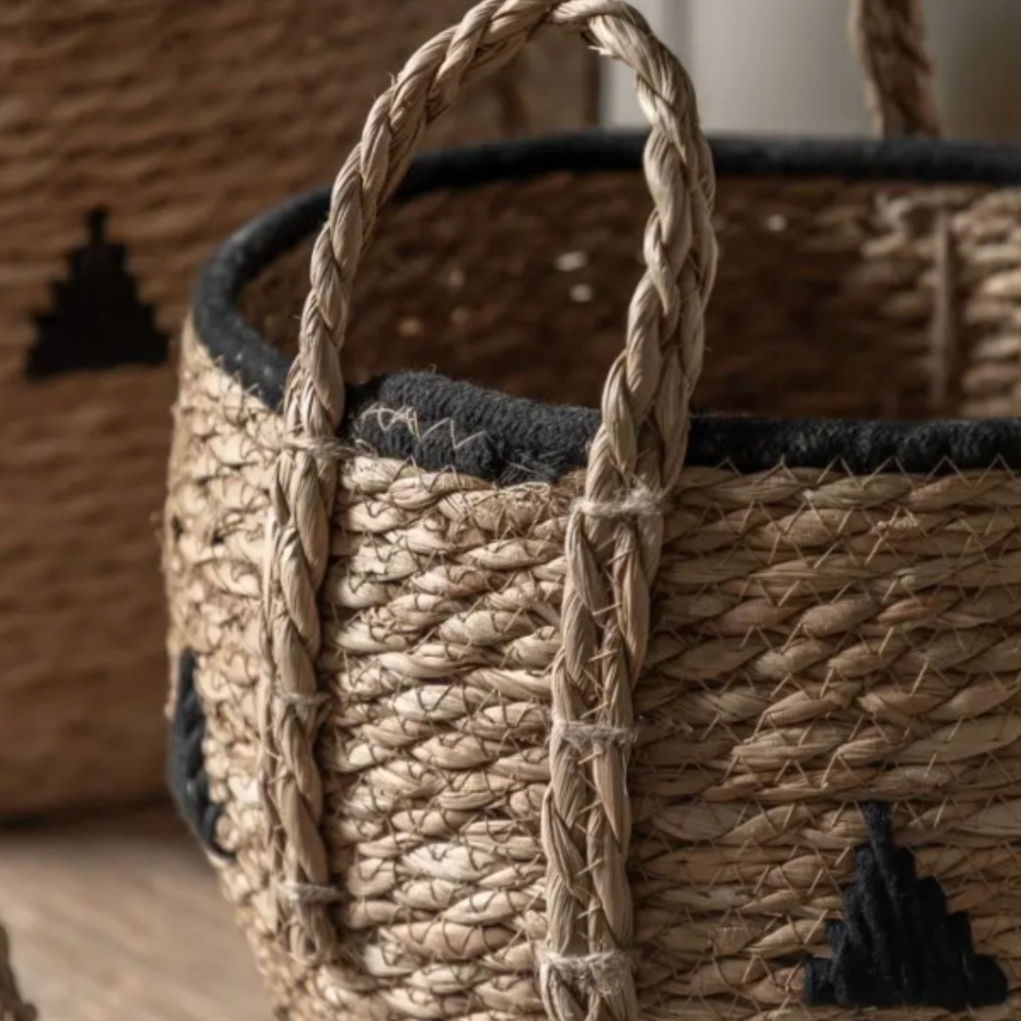 Close-up of a woven basket with braided handle on a wooden surface