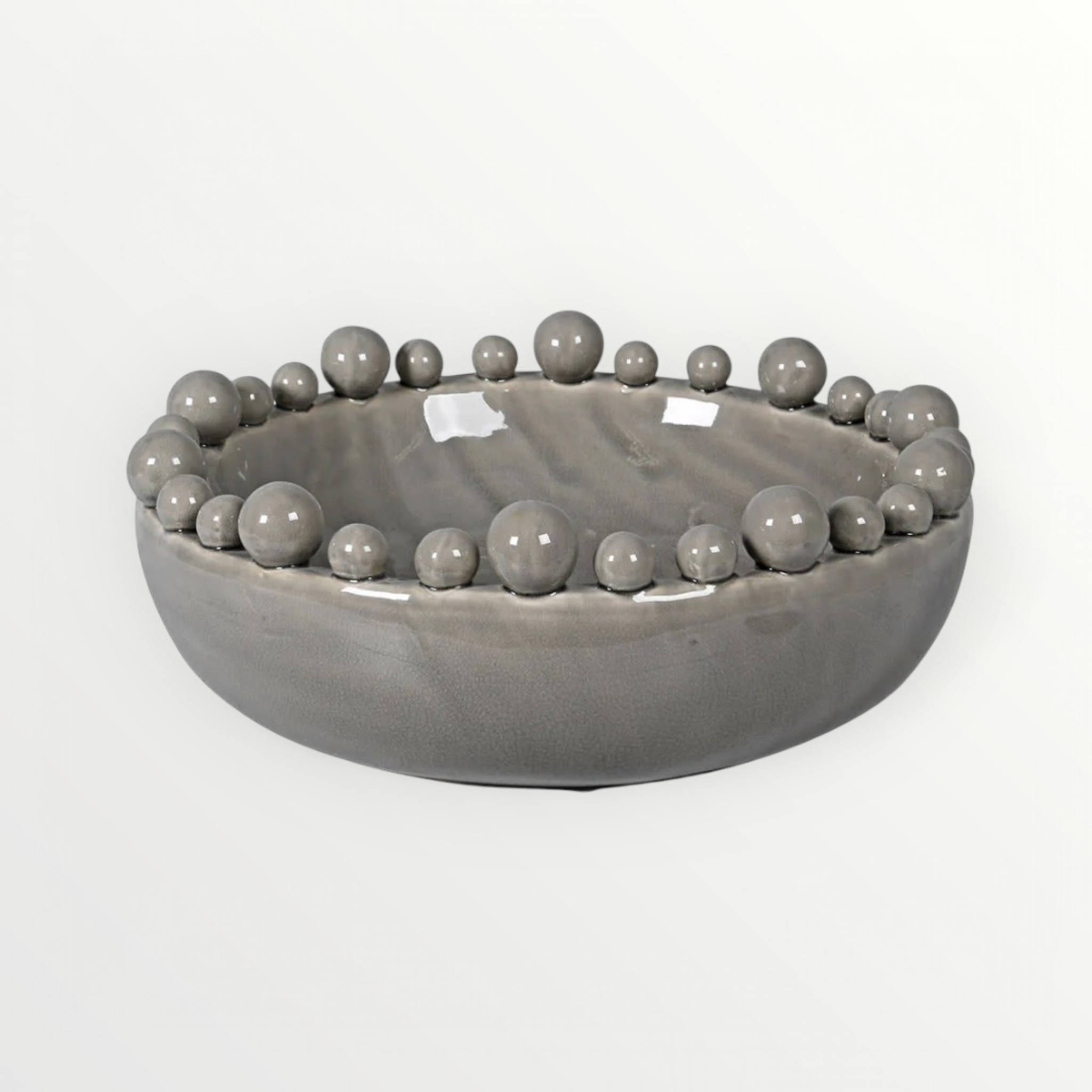 A grey ceramic bowl with a bobbled edge design