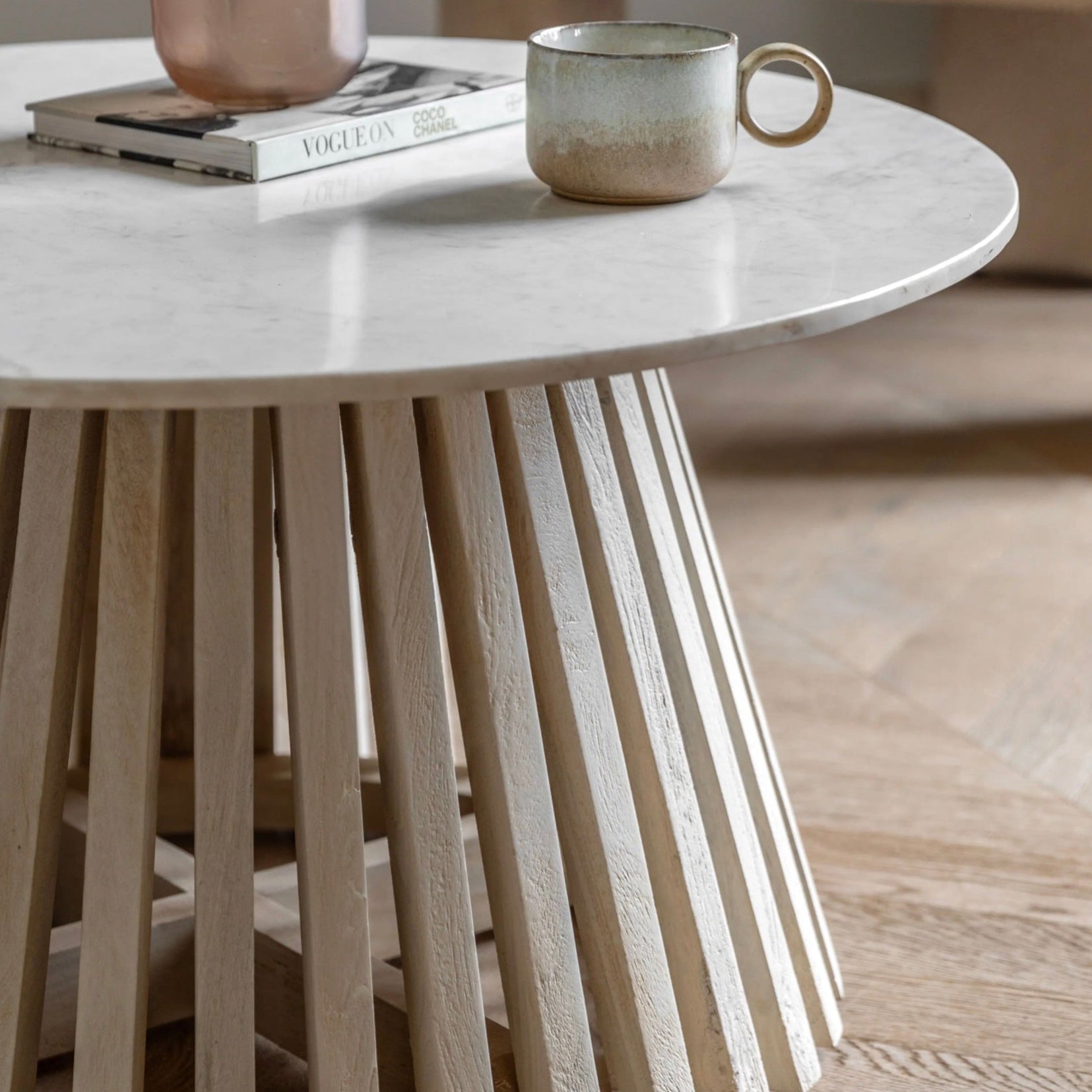 Round marble table with wooden legs in a minimalistic setting