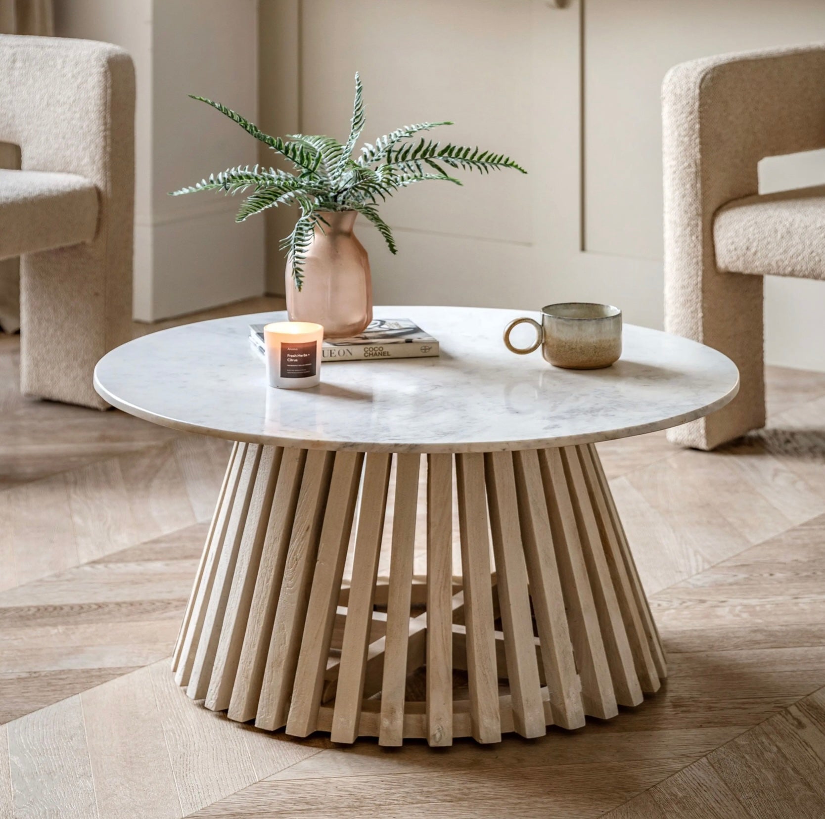 Round marble coffee table with wooden base in a living room setting