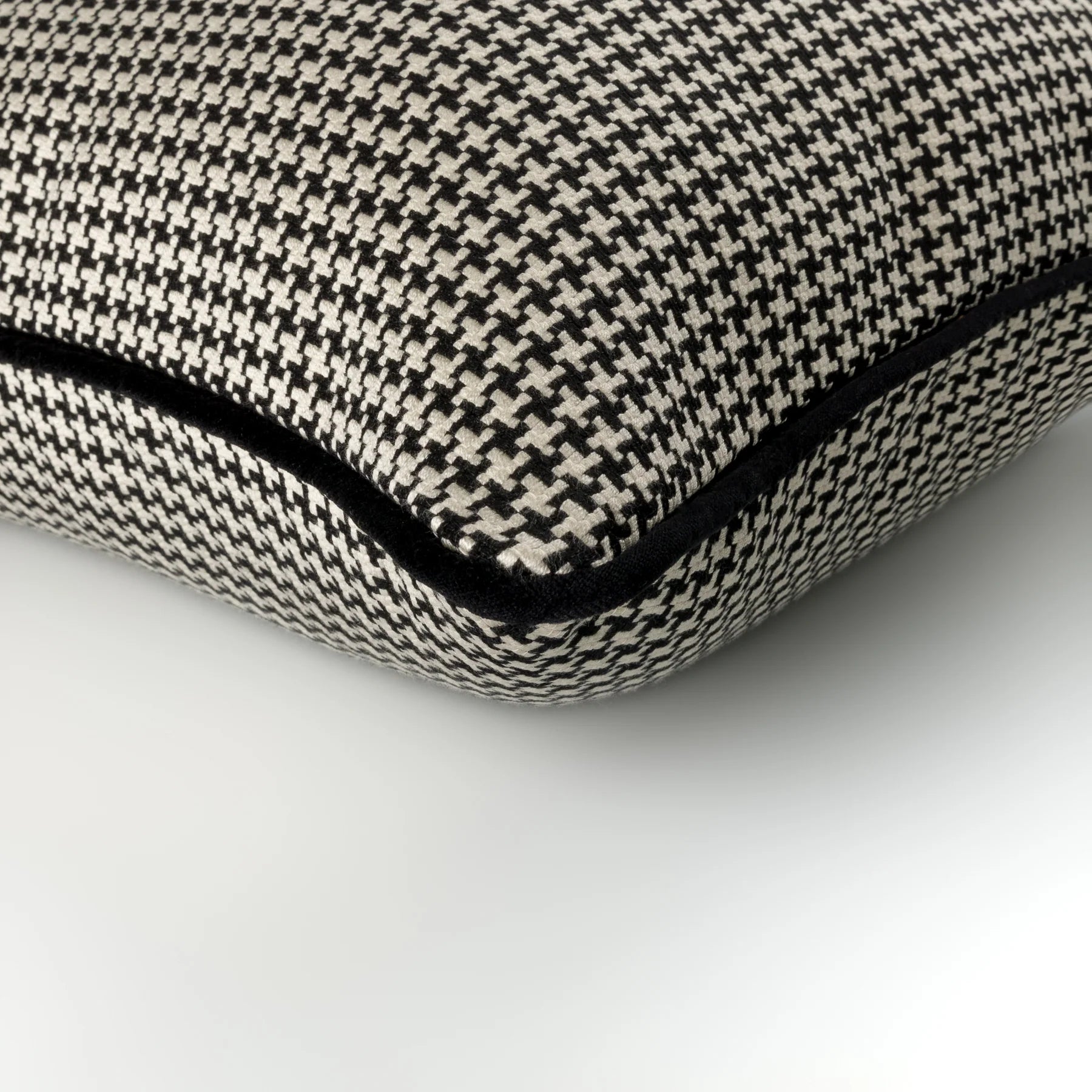 Houndstooth patterned cushion with a black border on a white background