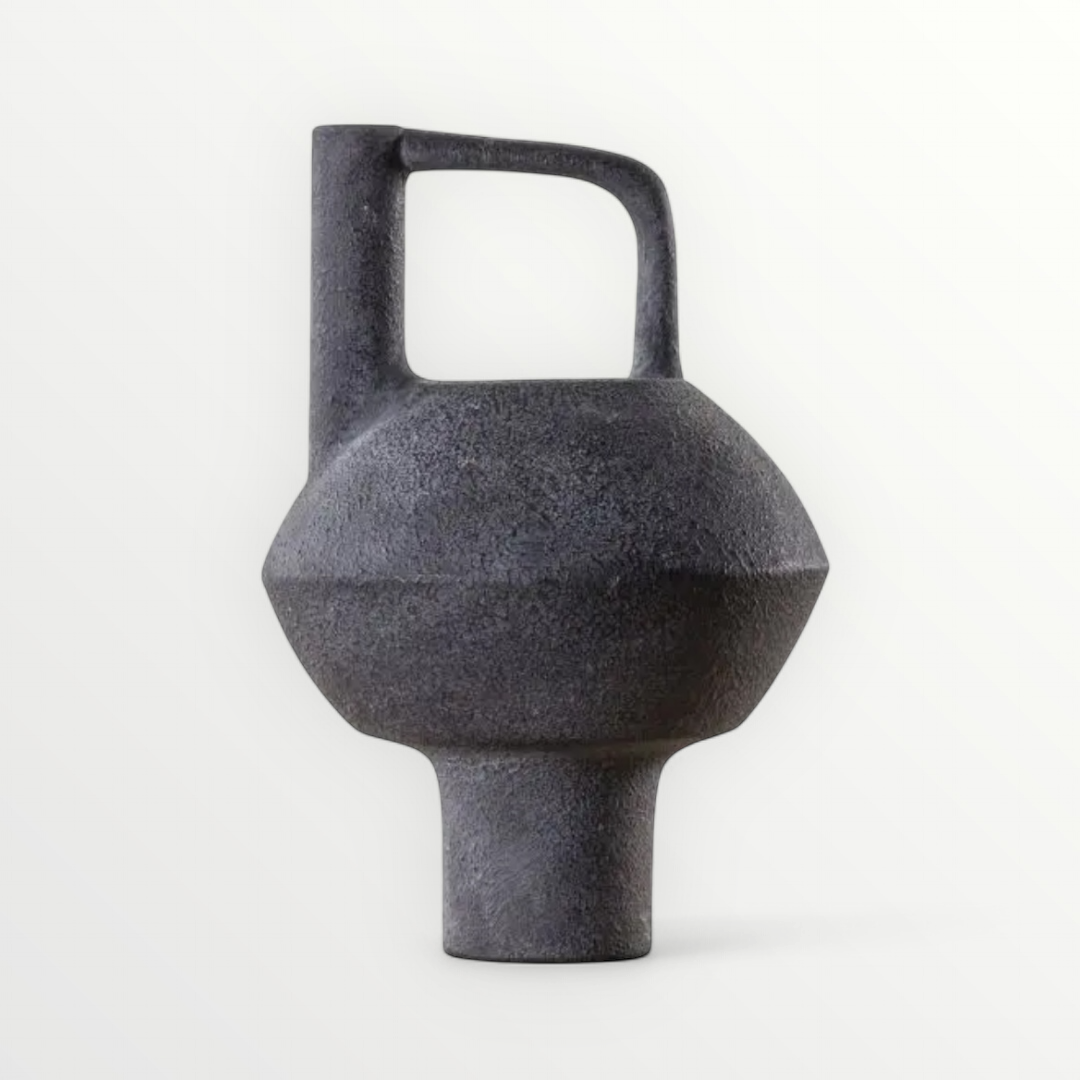 A minimalist stoneware vase with a neutral grey tone, featuring a clean, rounded design with an asymmetrical handle.
