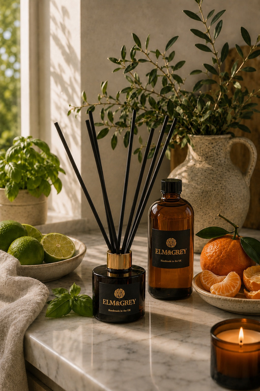 Elm & Grey Lime Basil & Mandarin reed diffuser with refill bottle styled on a marble worktop with fresh citrus and basil in a bright luxury kitchen.
