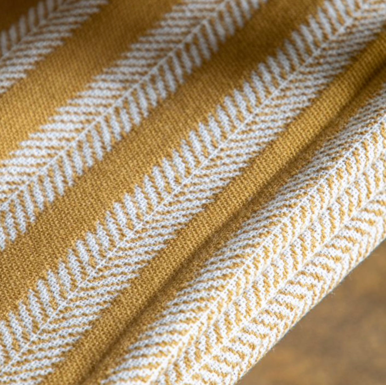 Close-up of a fabric with a herringbone pattern in mustard yellow and white., Elm & Grey