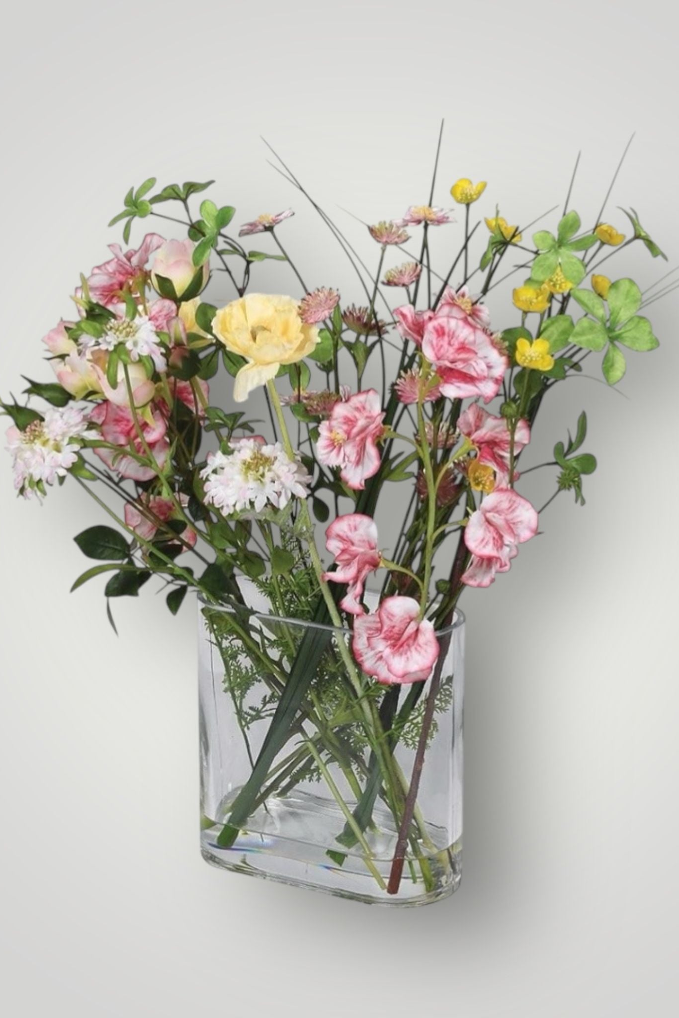 faux spring flowers set in resin in a glass vase on a white background