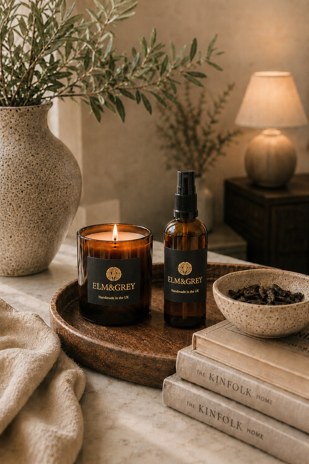Elm & Grey Myrrh & Tonka room spray and scented candle in a cosy living room setting with warm ambient lighting and luxury home styling
