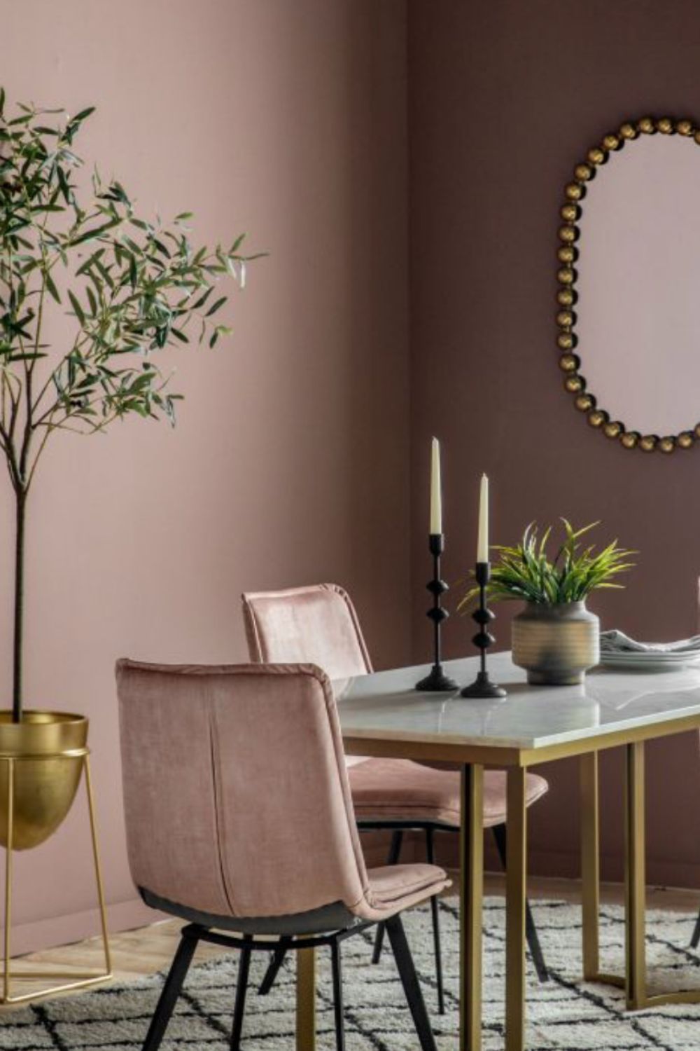 Dining room with pink walls, pink chairs, and a marble table.