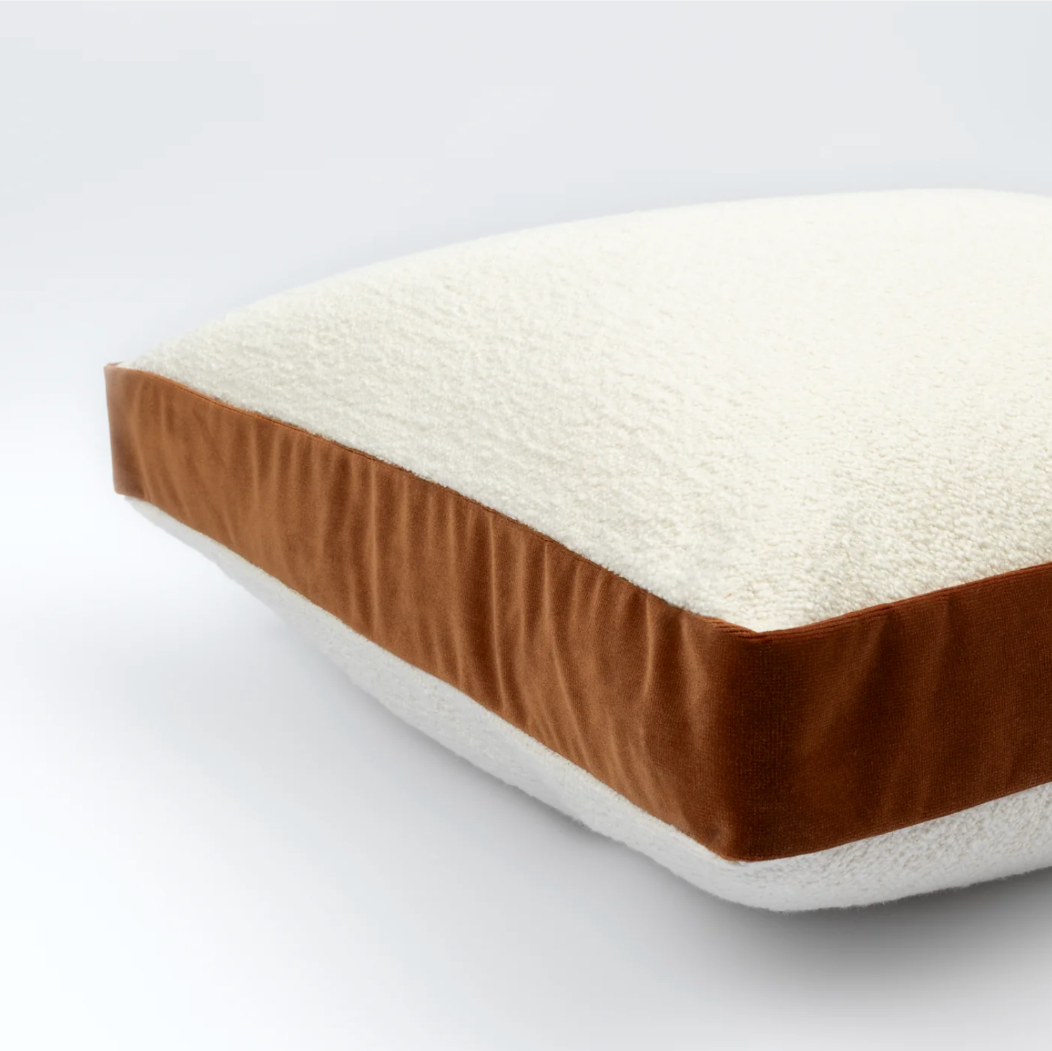 Rectangular mattress with brown and white sides on a plain background