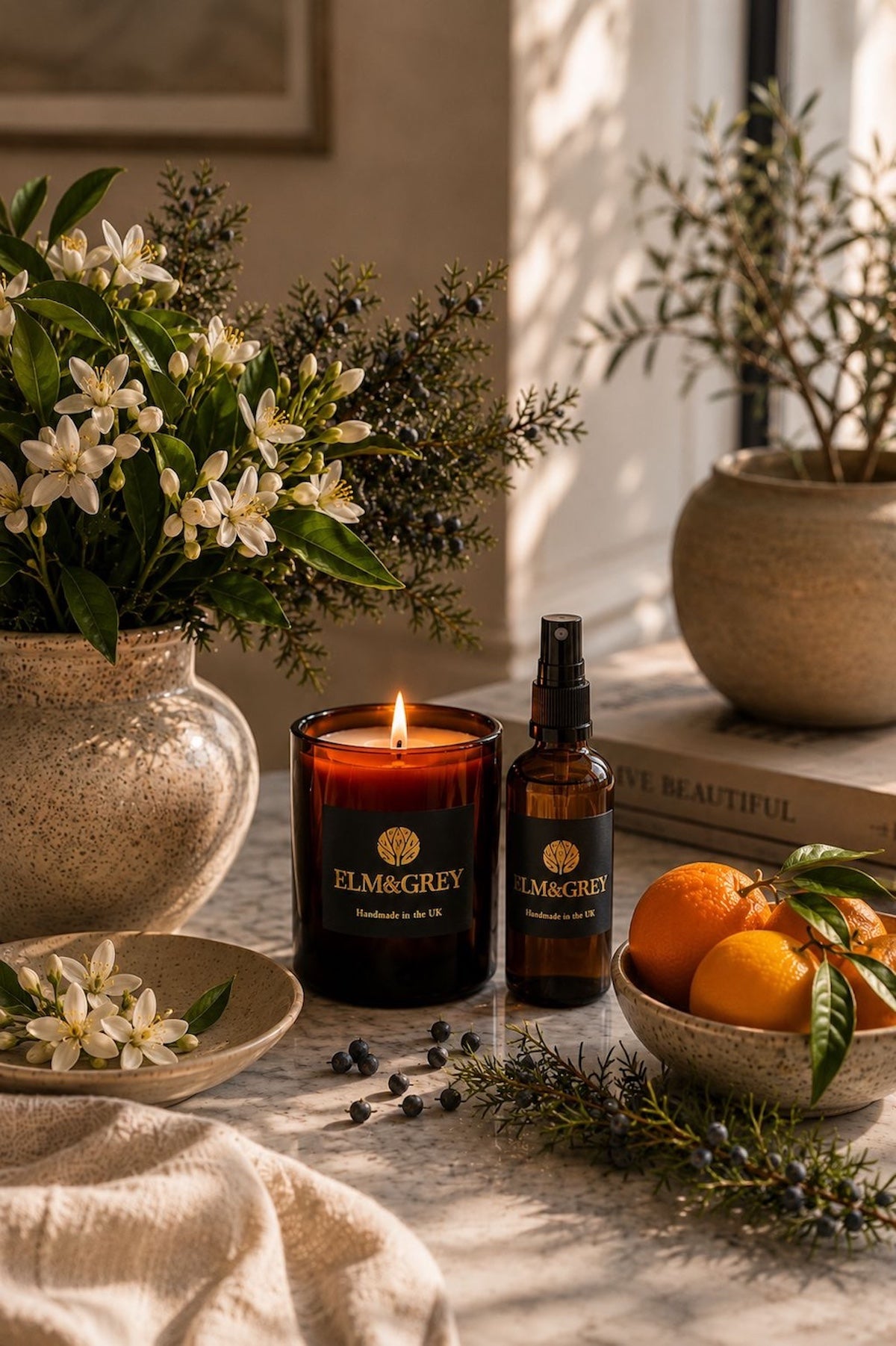 Elm & Grey Orange Blossom & Juniper luxury home fragrance featuring a hand-poured scented candle and room spray styled with fresh citrus, orange blossom and aromatic juniper.