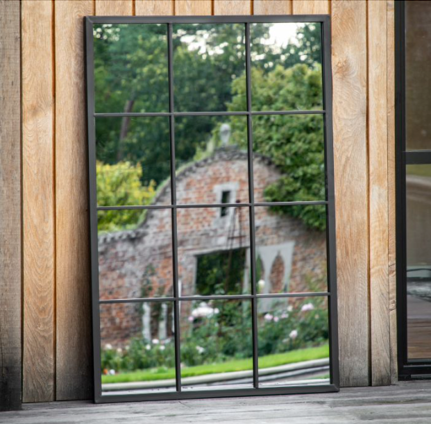 A sleek black outdoor mirror with a pane design, hanging on a wooden wall.