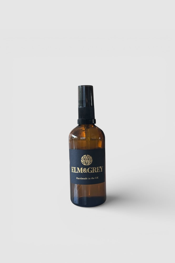Amber room spray bottle with a label on a white background