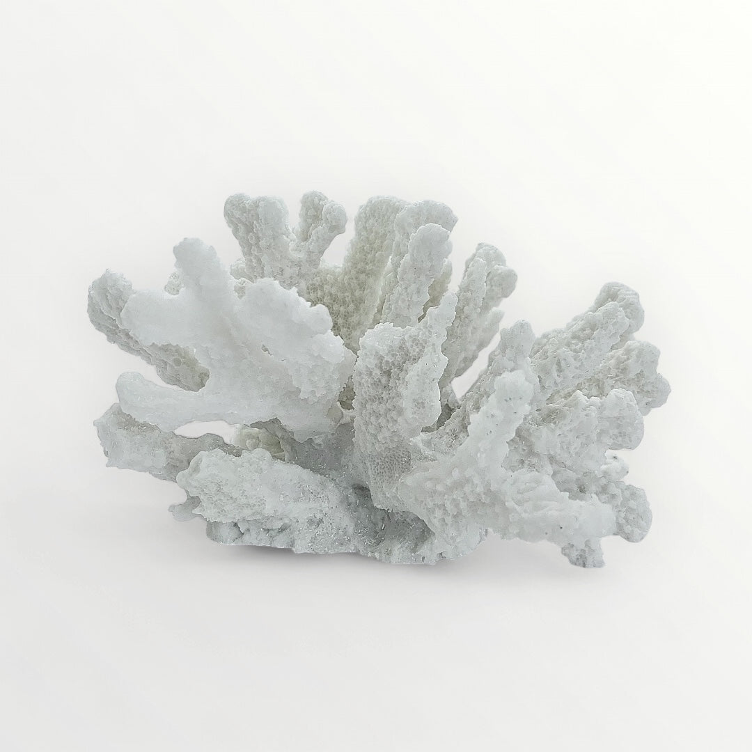 A small, natural off white faux coral sculpture made from polyresin, with a stone-like texture.