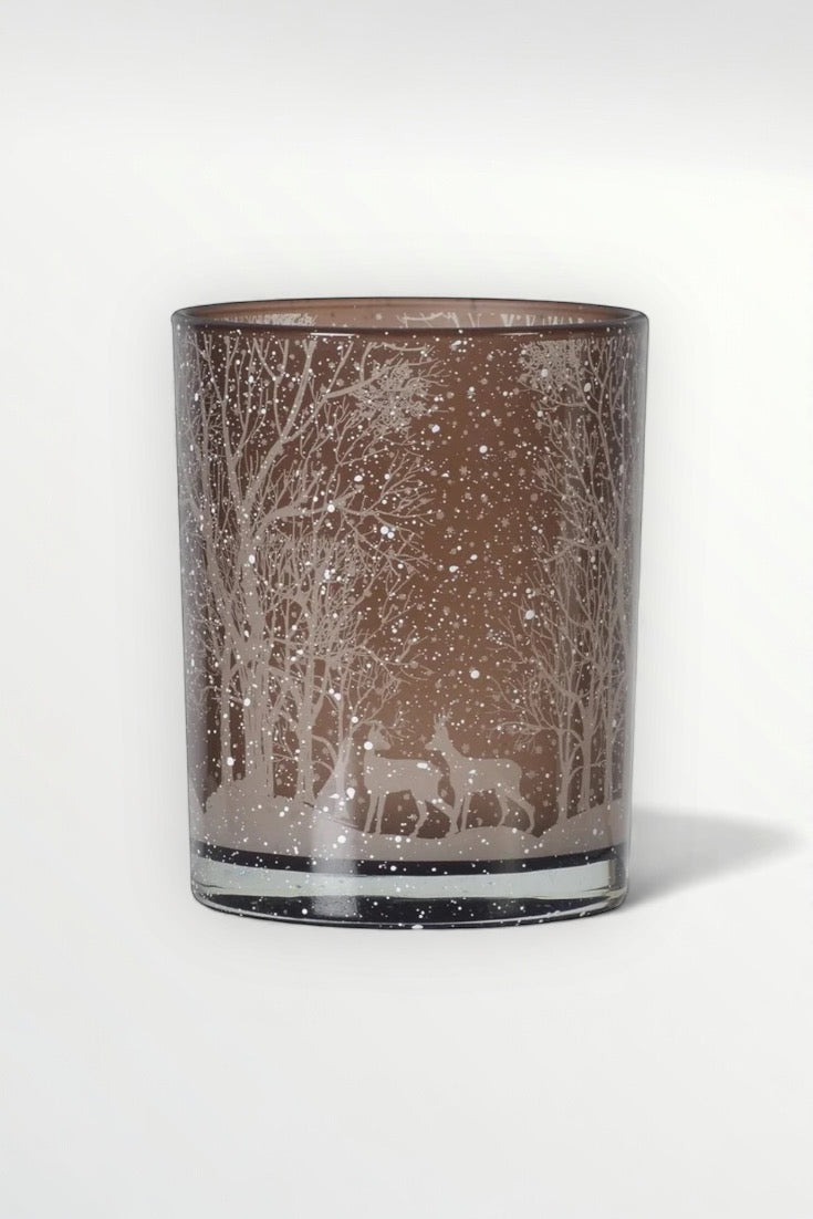 Decorative glass with winter scene of deer and trees on a white background
