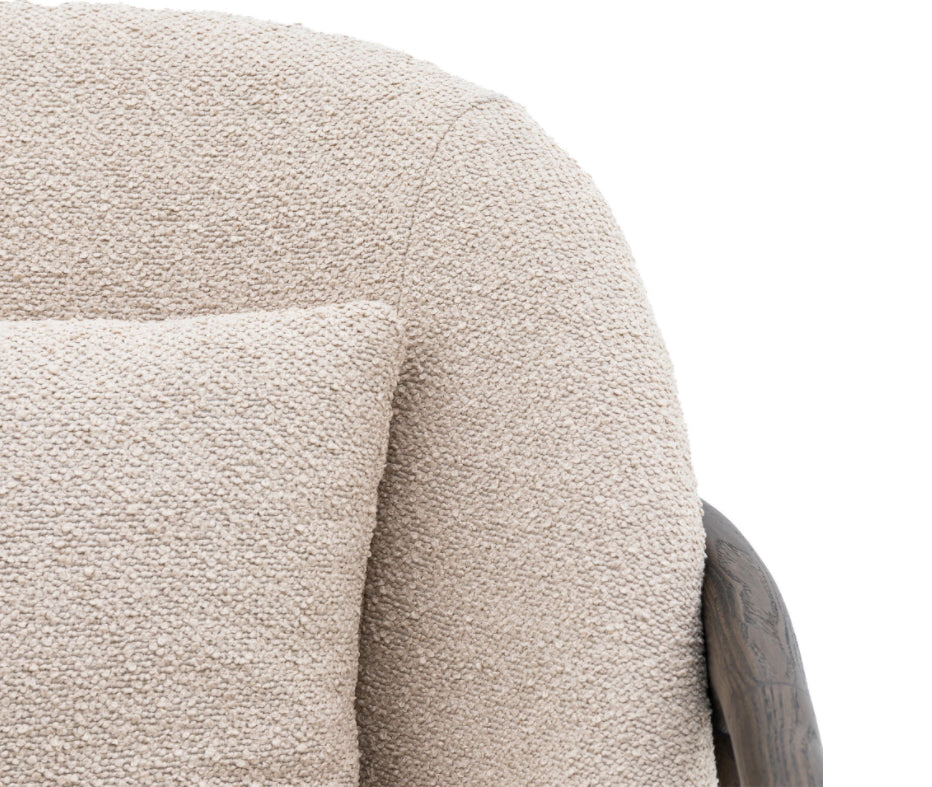 Close-up of a textured taupe  armchair with a pillow on a white background, Elm & Grey.