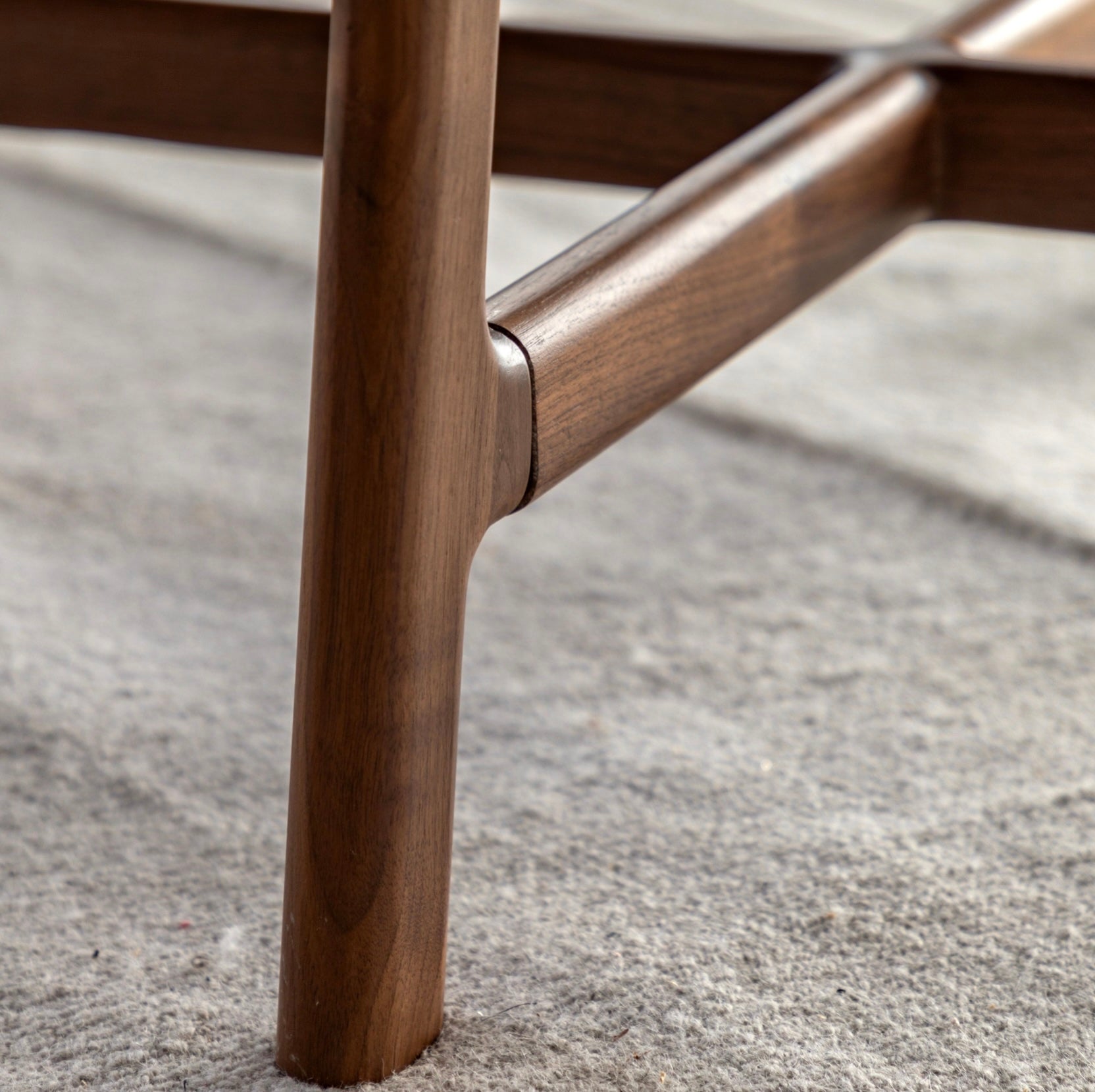Close-up of a wooden coffee table leg on a rug