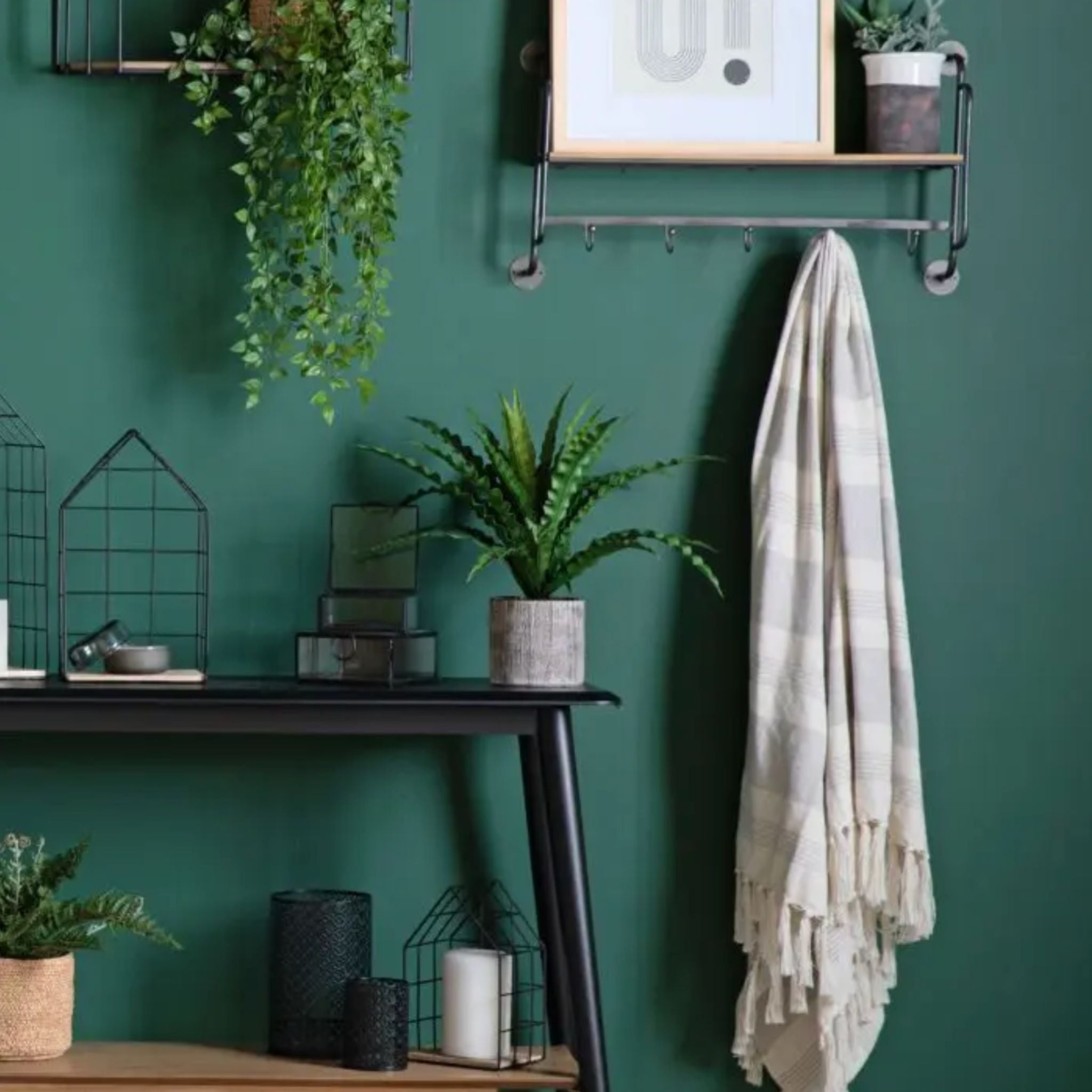 Nestled corner with a dark green wall, featuring a small table with plants and decor items.