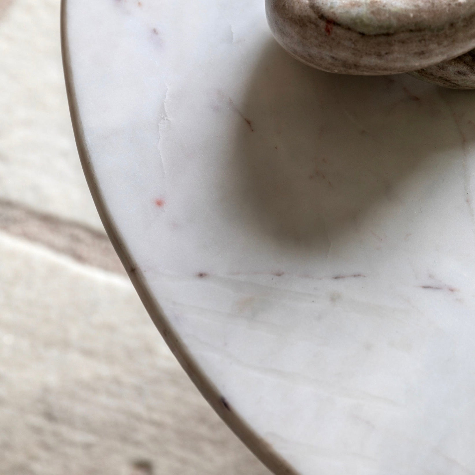 Close-up of a marble coffee table top with a stone decor object on it