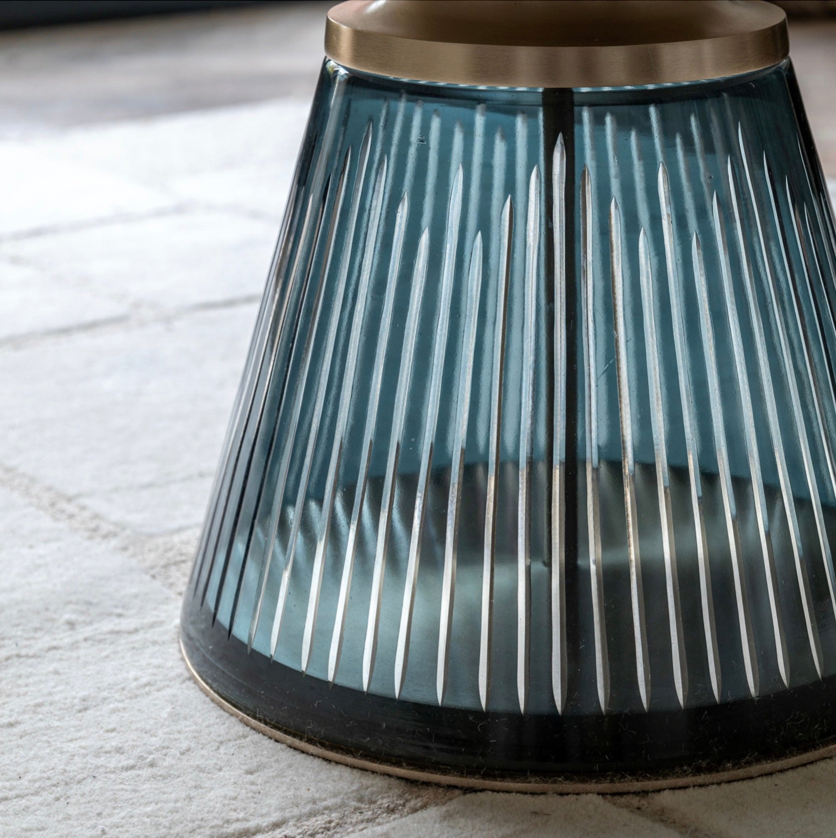 Decorative glass table with ribbed design on a light stone coloured rug