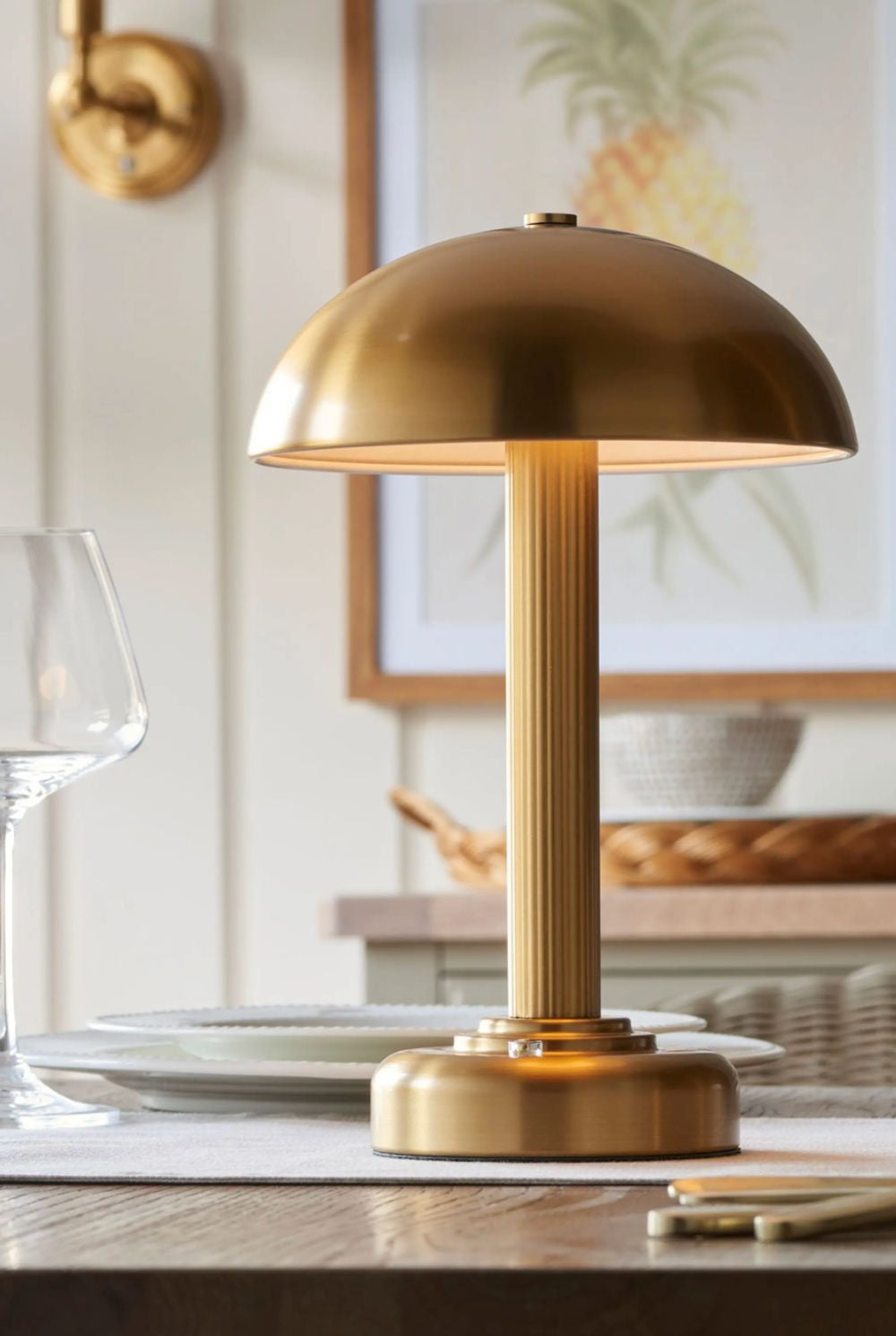 Warm brass table lamp on a wooden surface with a blurred background