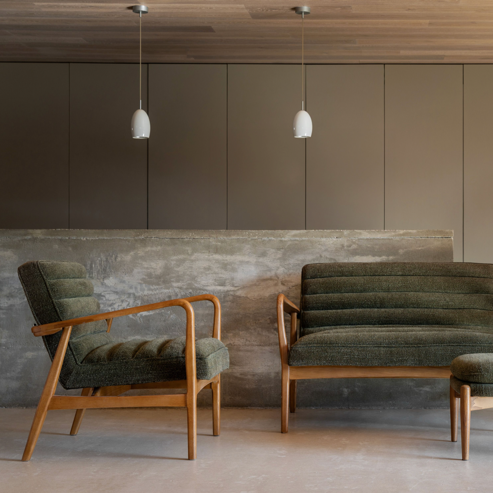 Modern living room with green upholstered chairs and a gray wall.