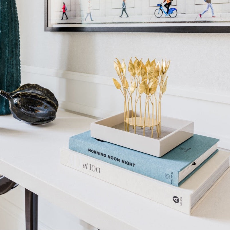 Pre-Styled Square High Gloss Lacquer Tray with Brass Pea Pod Hurricane Lantern on a pile of books morning noon and night