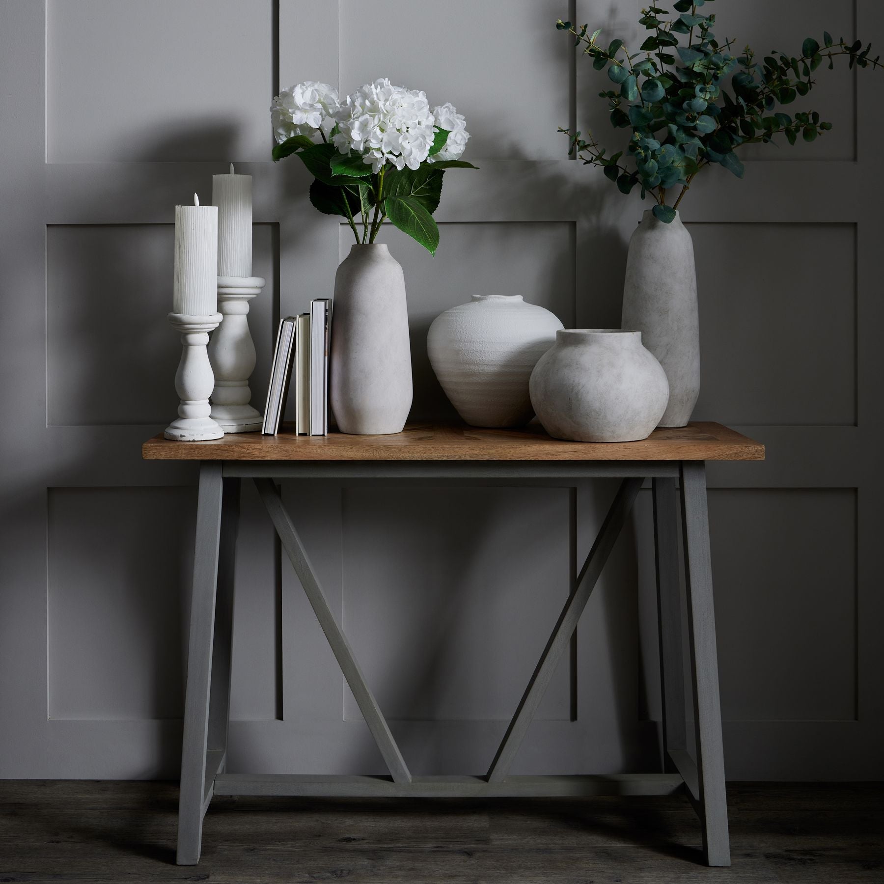 Collection of stone vases and planter on a console table